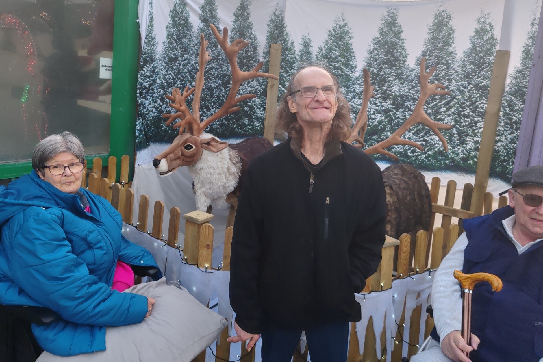 Group of people smiling at the camera, while standing at a garden centre display