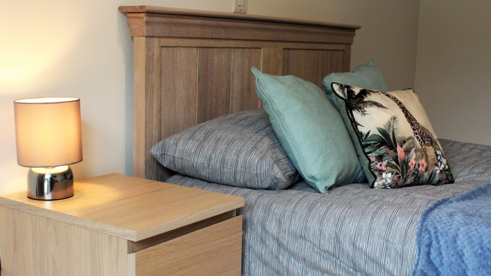 Bedroom photo bed with cushions and lamp on bedside table