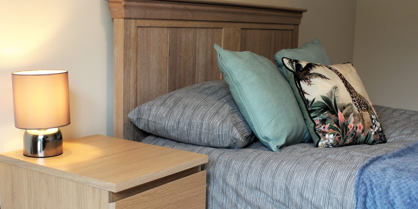 Bedroom photo bed with cushions and lamp on bedside table