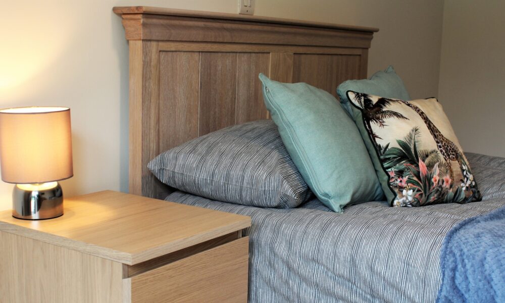 Bedroom photo bed with cushions and lamp on bedside table